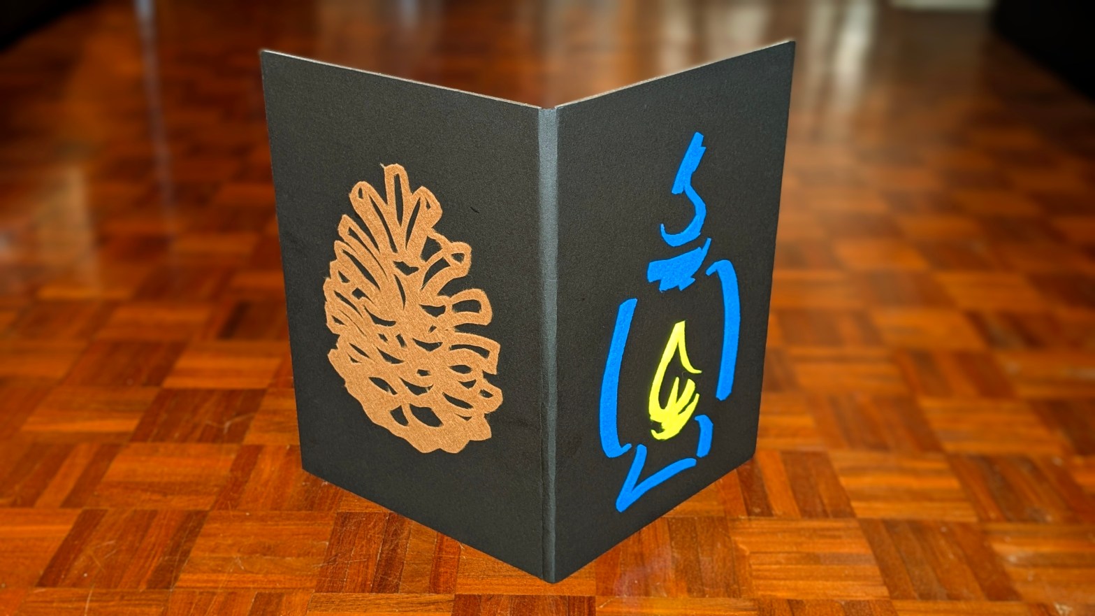 Capa do livro com uma pinha e o símbolo Candeia